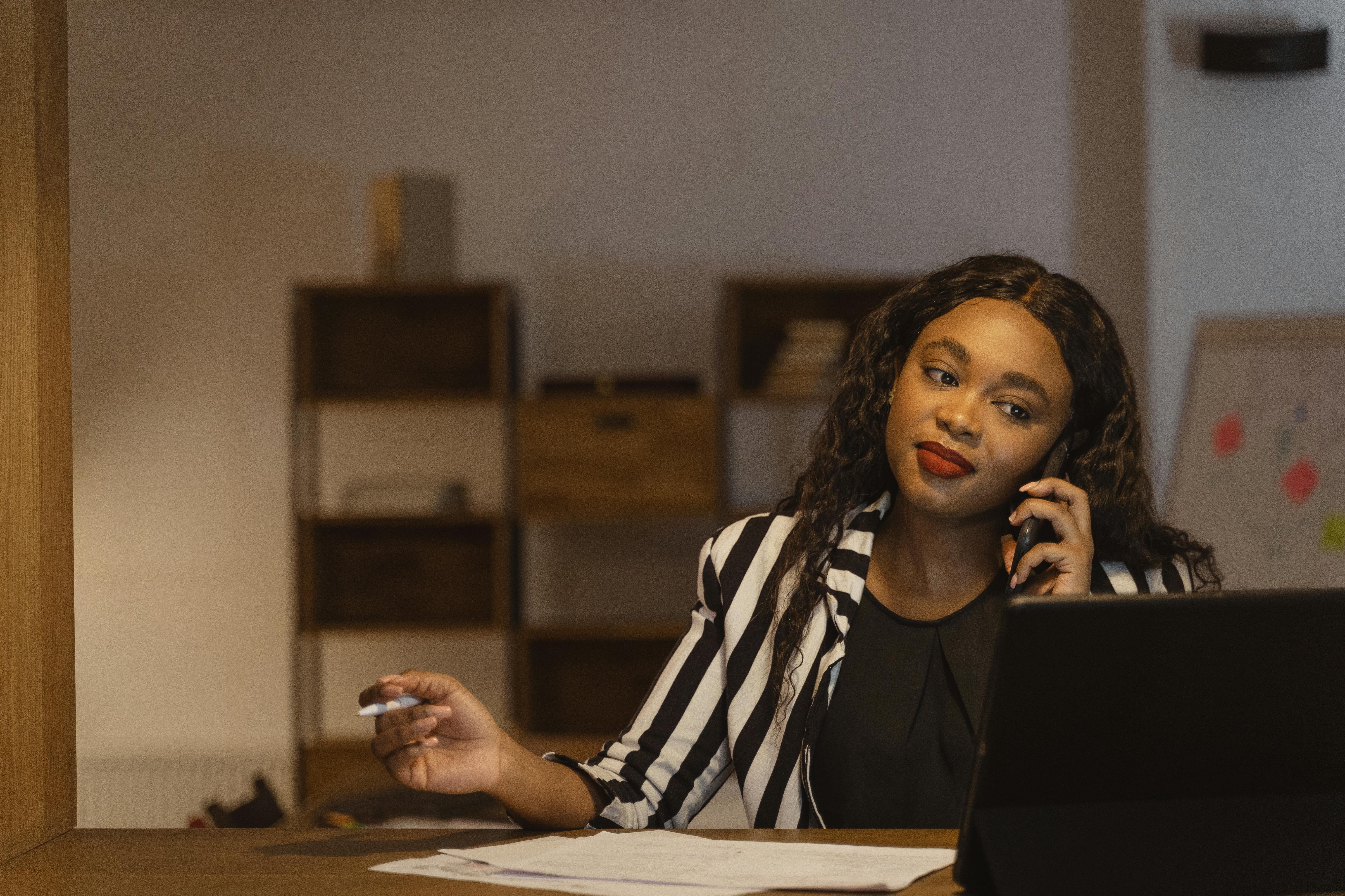 African businesswoman on phone in modern office