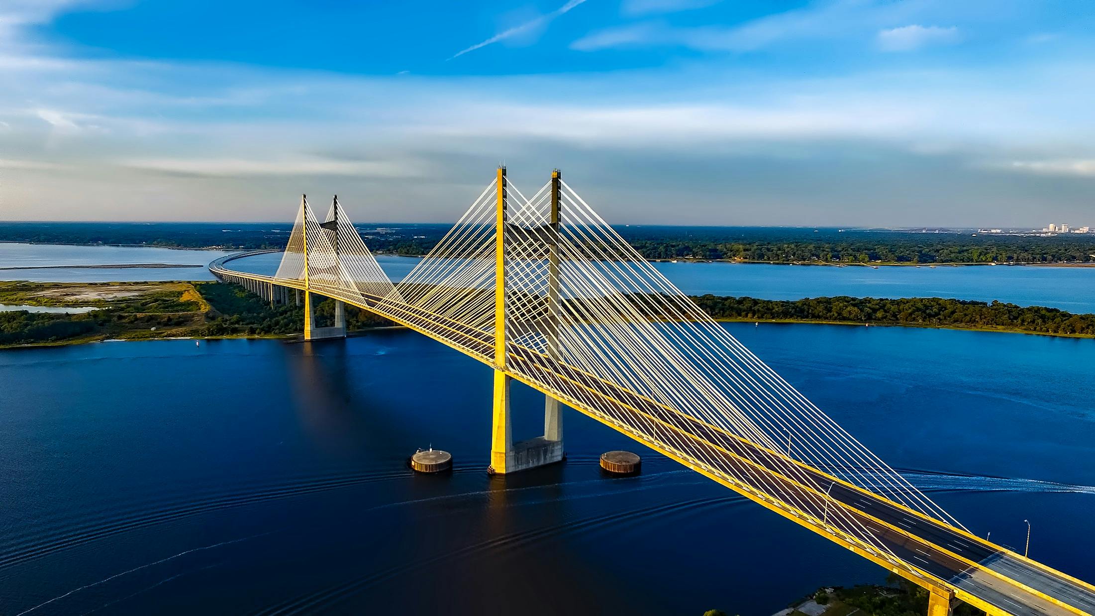 Aerial view of golden cable-stayed bridge spanning blue water, symbolizing connection between continents