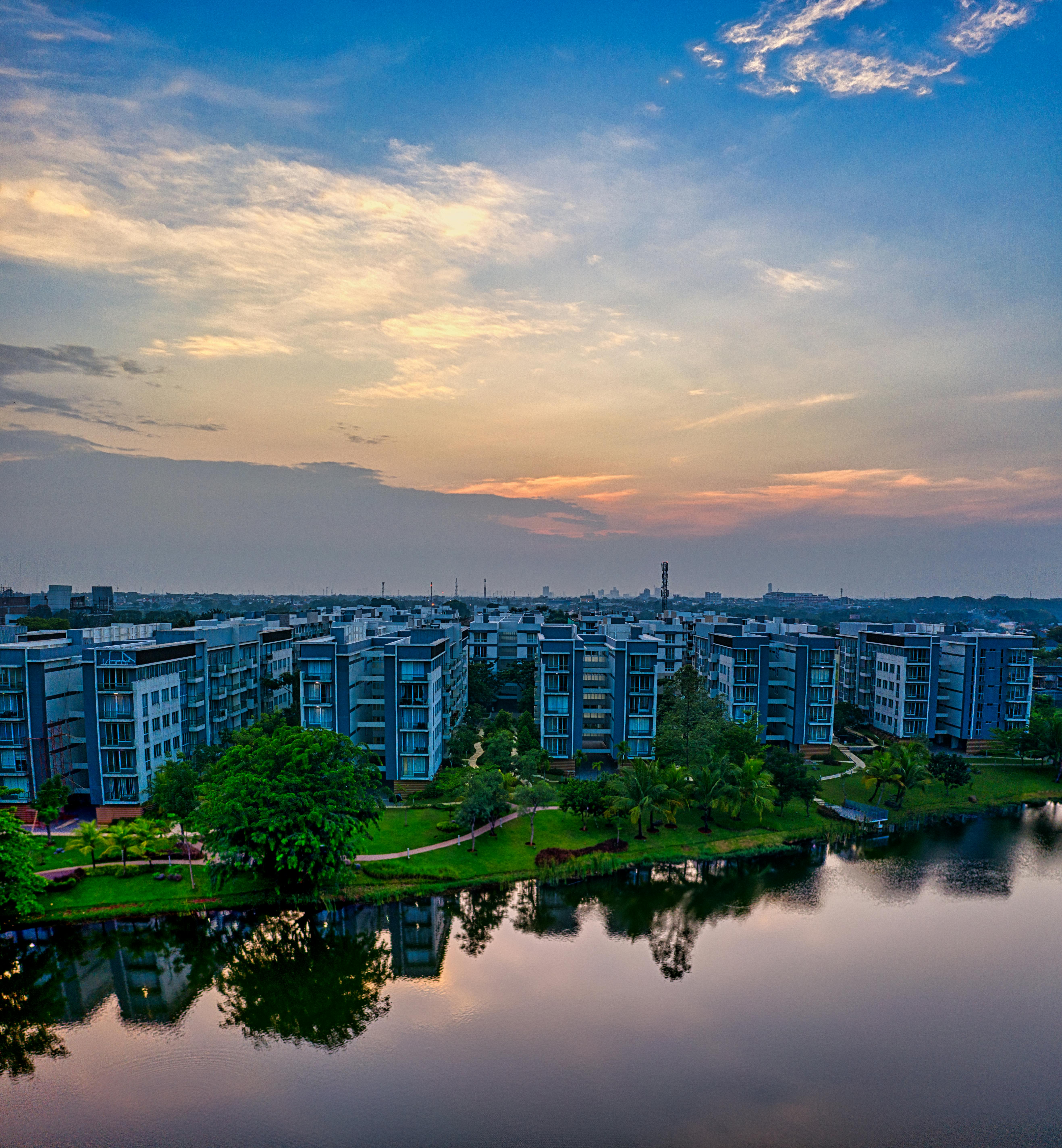 Modern waterfront residential development at sunset with tropical landscaping